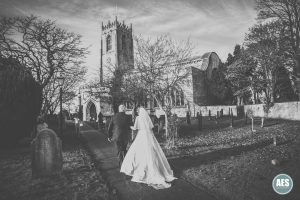 Bride and father-in-law walking towards St Mary and Martins Church in Blyth
