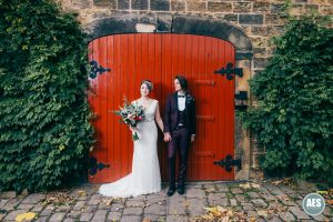 Bride and Groom in front of the red door at Wood Lane Countryside Centre